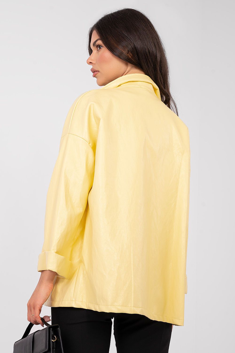 Woman wearing a yellow blazer against a plain background