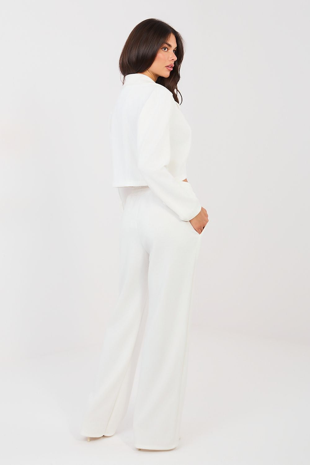 Woman wearing a white outfit on a plain background