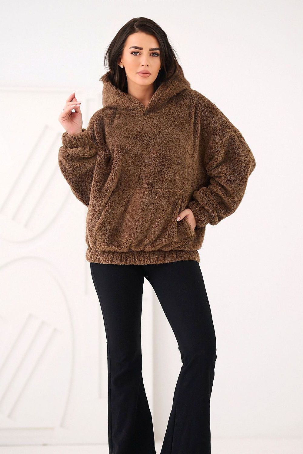 Woman wearing a brown fleece hoodie on a white background