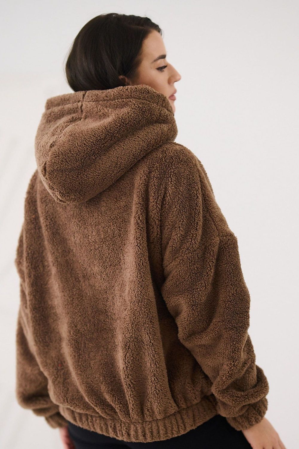 Person wearing a brown fleece jacket on a white background