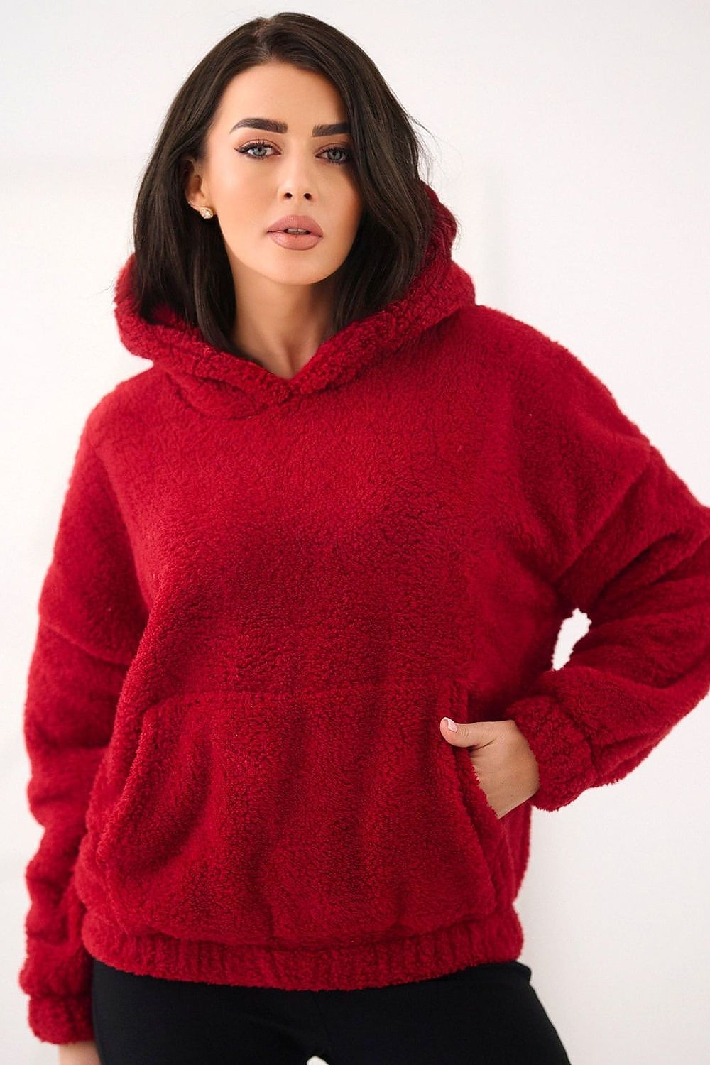 Woman wearing a red fleece hoodie against a white background