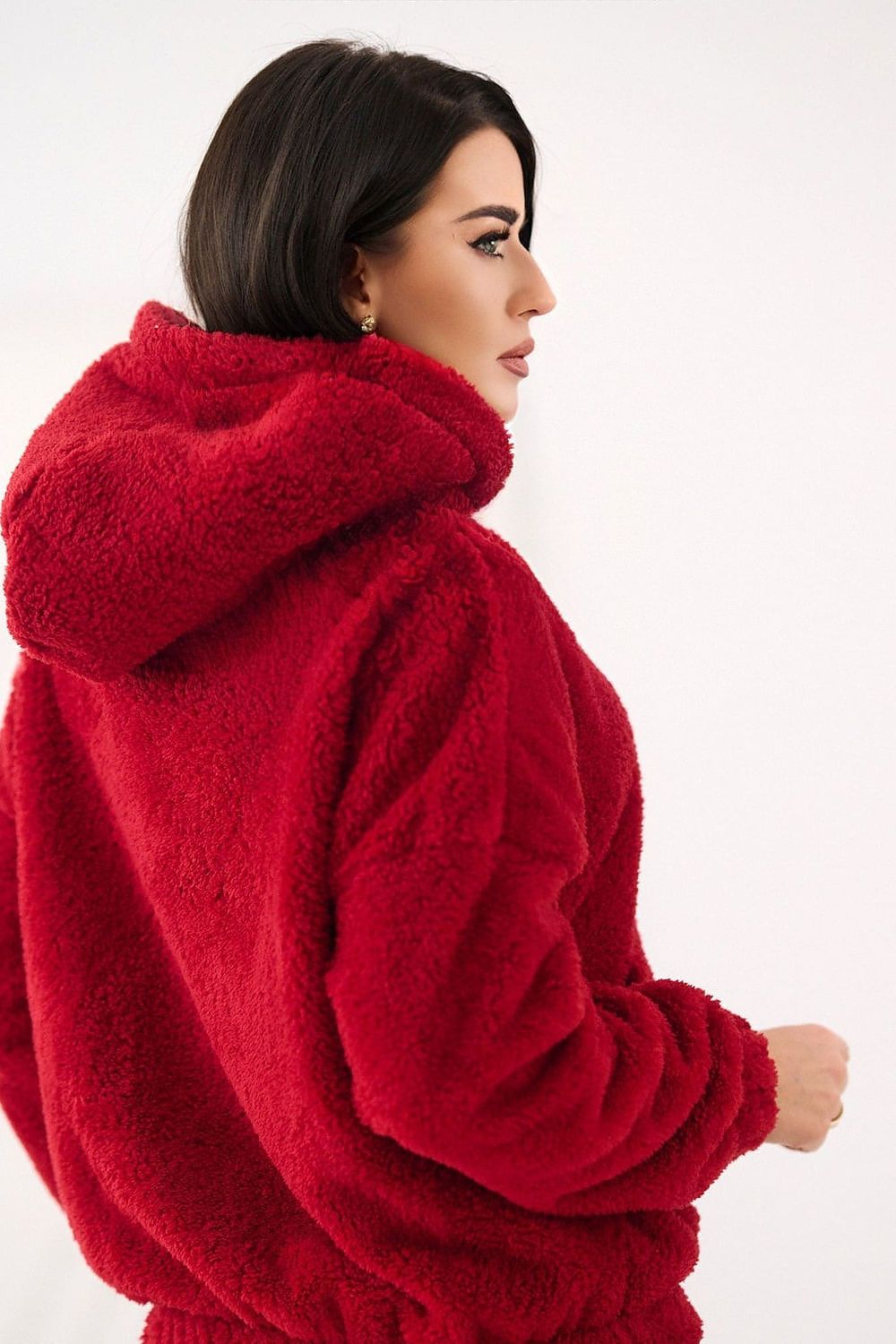 Woman wearing a red fluffy coat on a white background