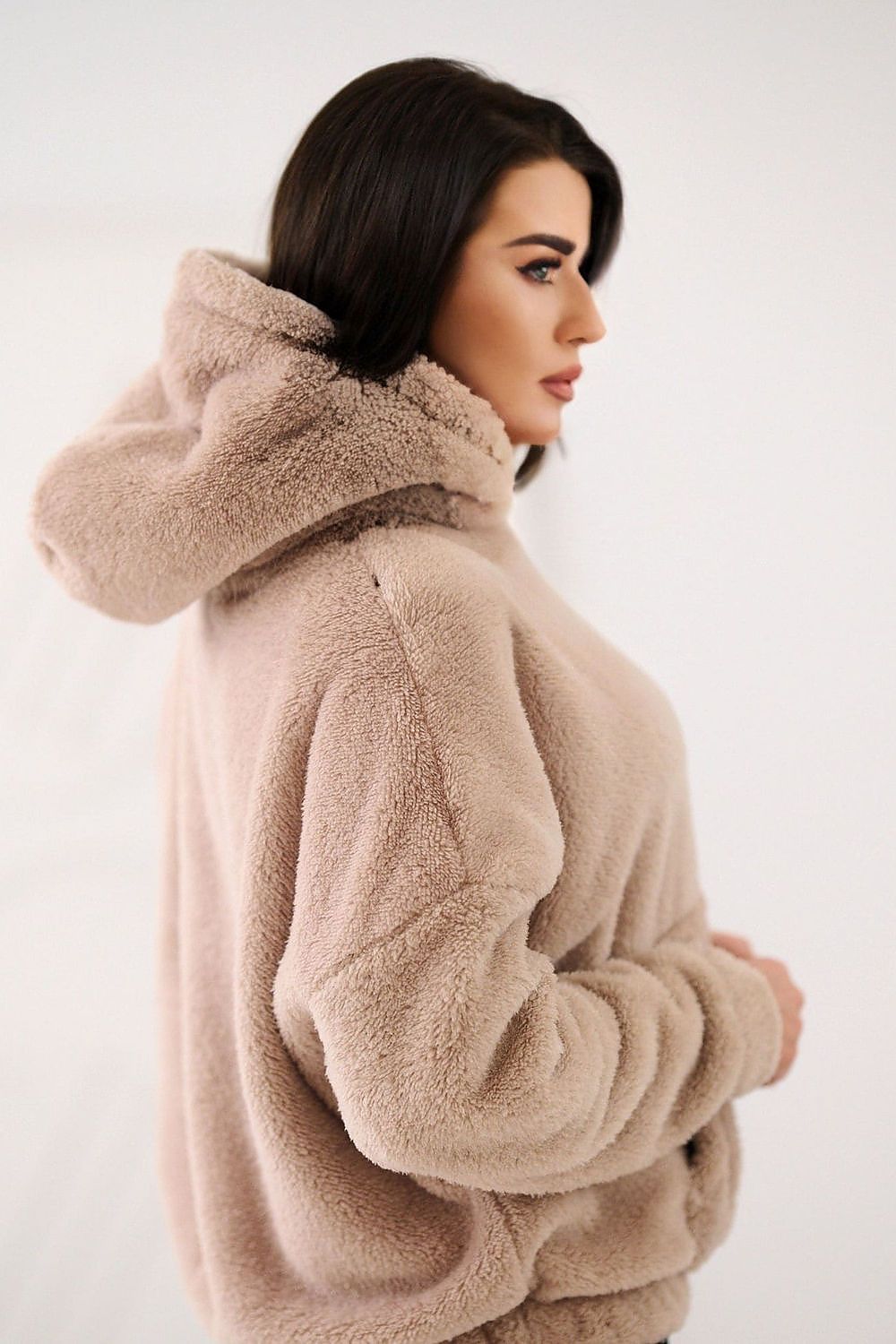 Woman wearing a beige fleece jacket on a white background