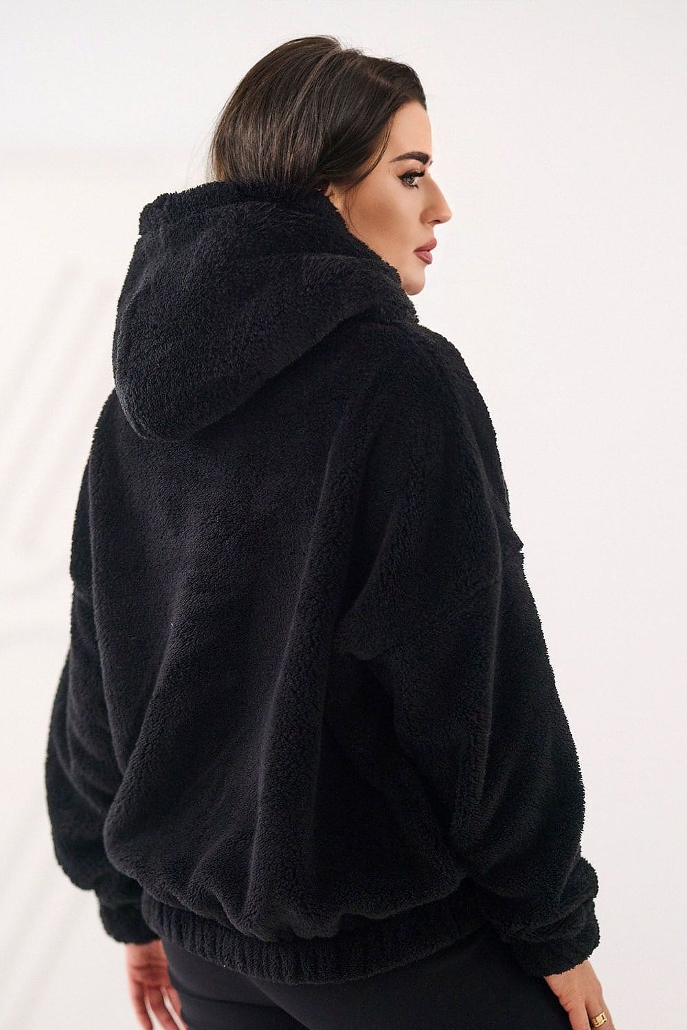 Woman wearing a black fleece jacket on a white background