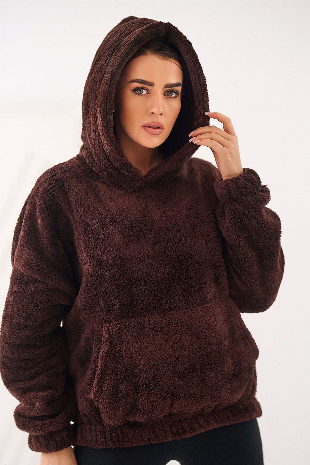 Woman wearing a brown fleece hoodie on a white background