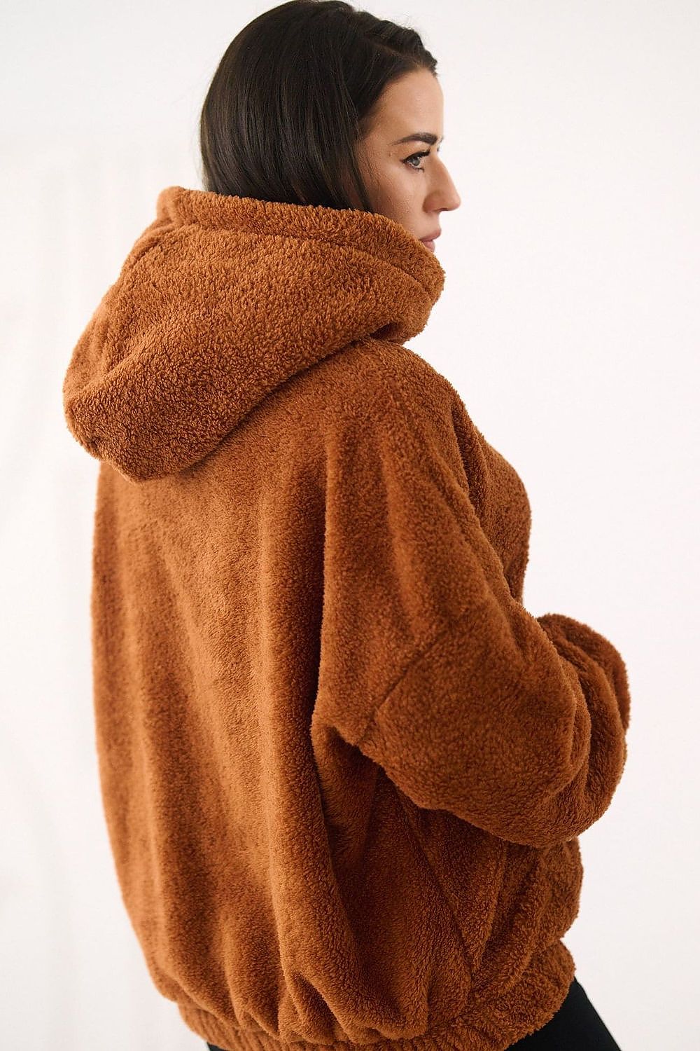Person wearing a brown fleece jacket on a white background