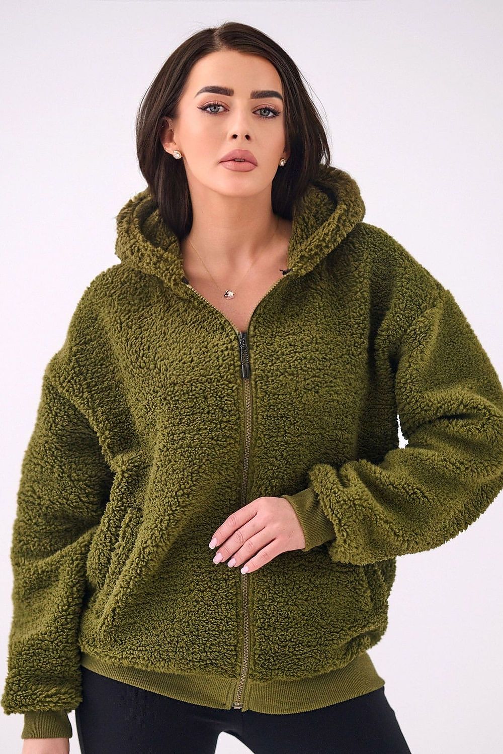 Woman wearing a green fleece jacket on a white background