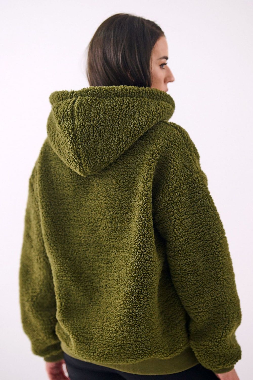 Person wearing a green fleece jacket on a white background
