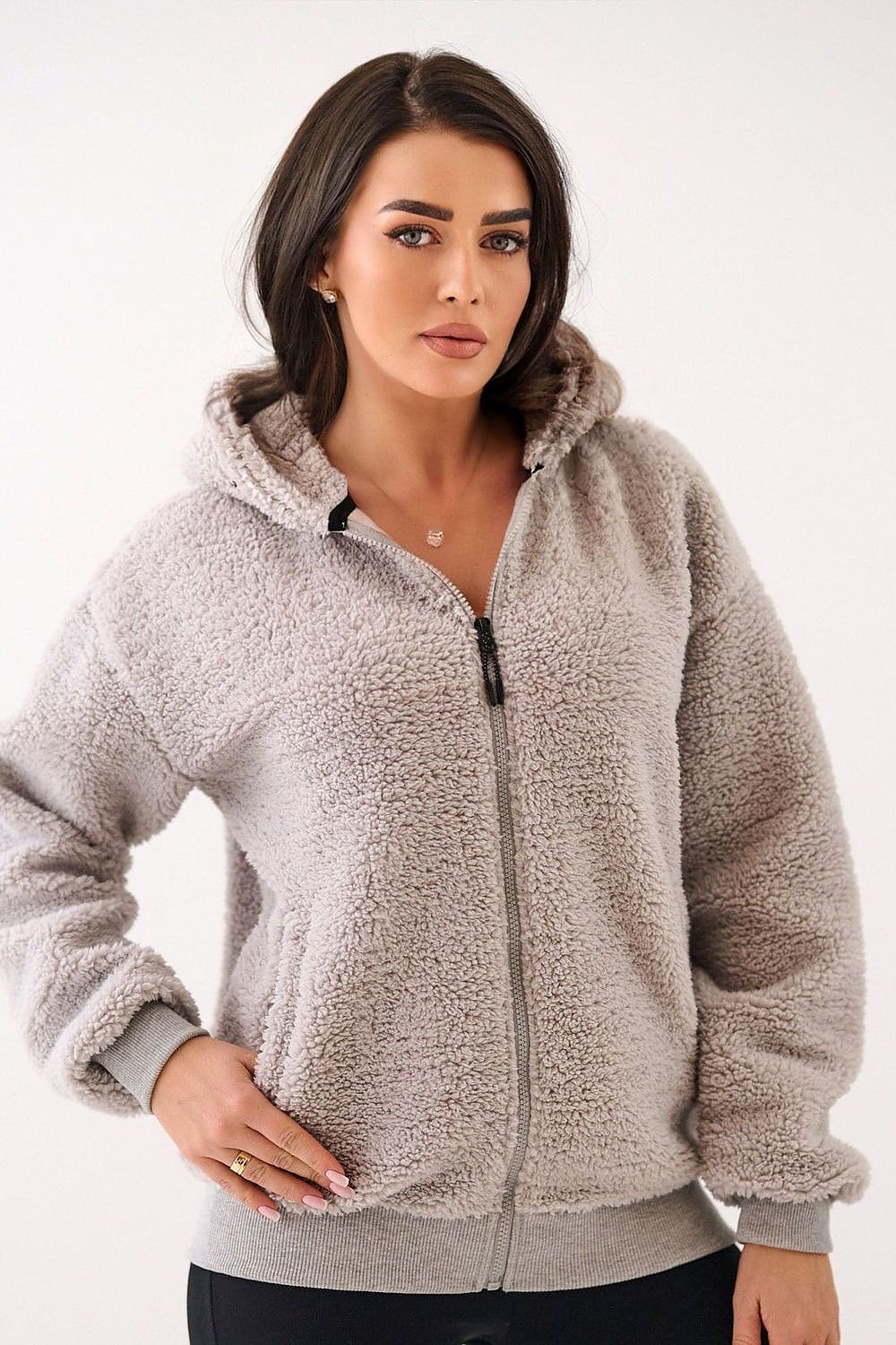 Woman wearing a beige fleece jacket on a white background