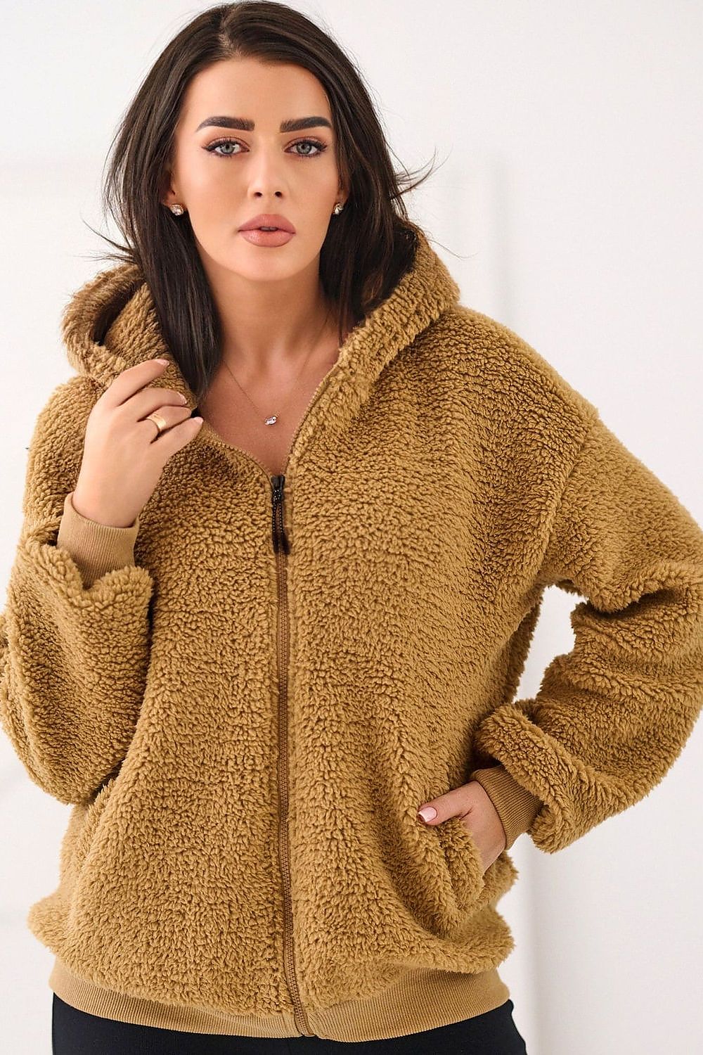 Woman wearing a brown fleece jacket against a white background