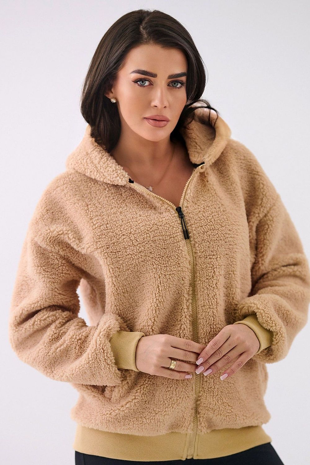 Woman wearing a beige fleece jacket on a white background