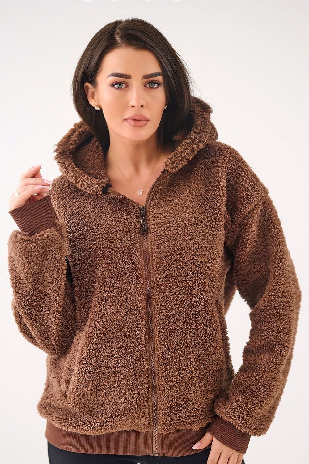 Woman wearing a brown sherpa jacket on a white background