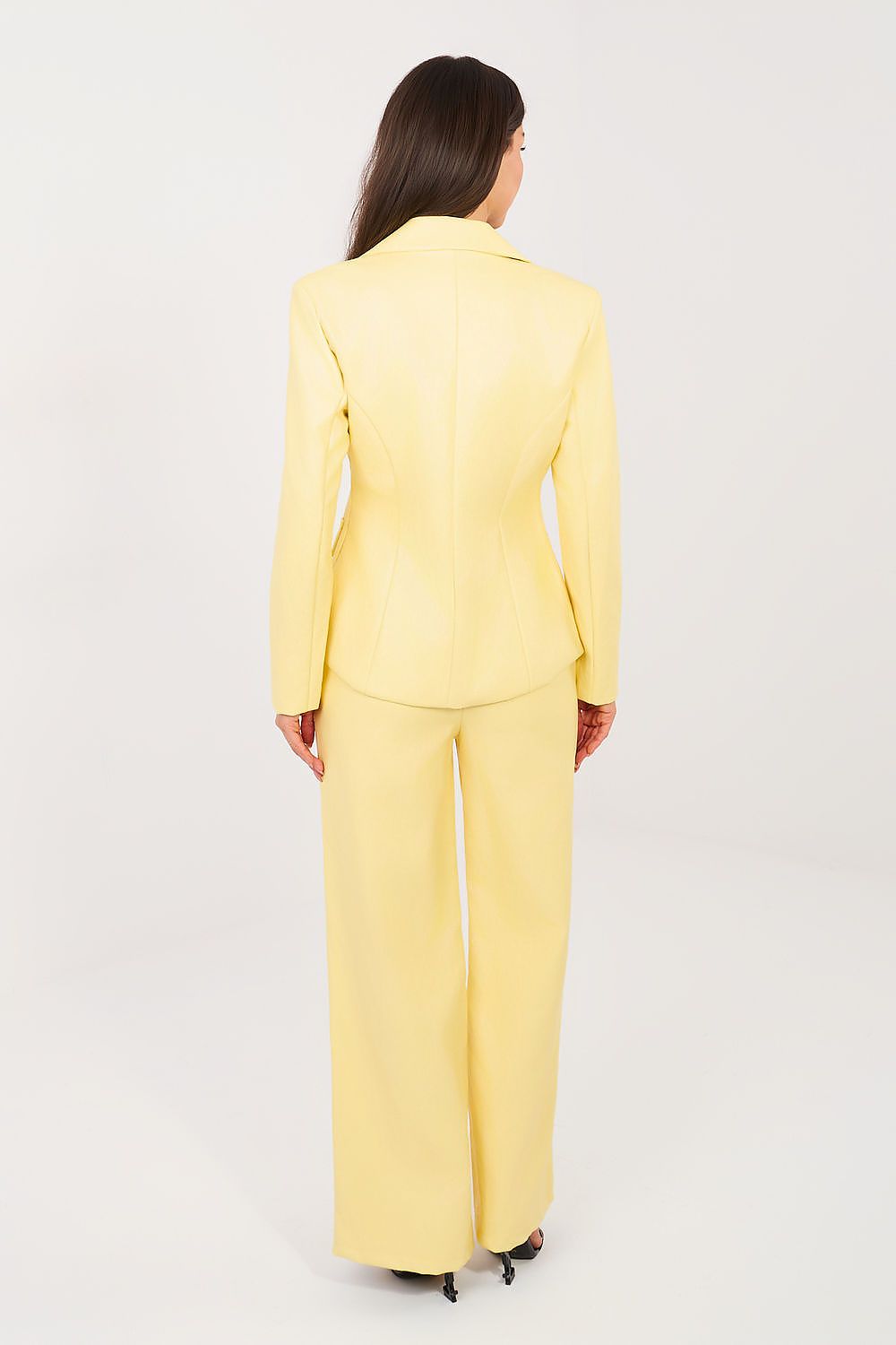 Woman wearing a yellow suit on a white background