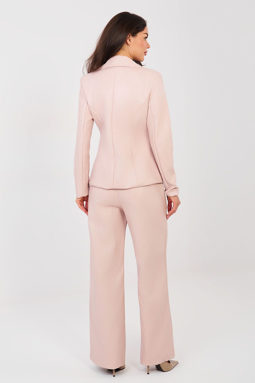 Woman wearing a light pink suit on a white background