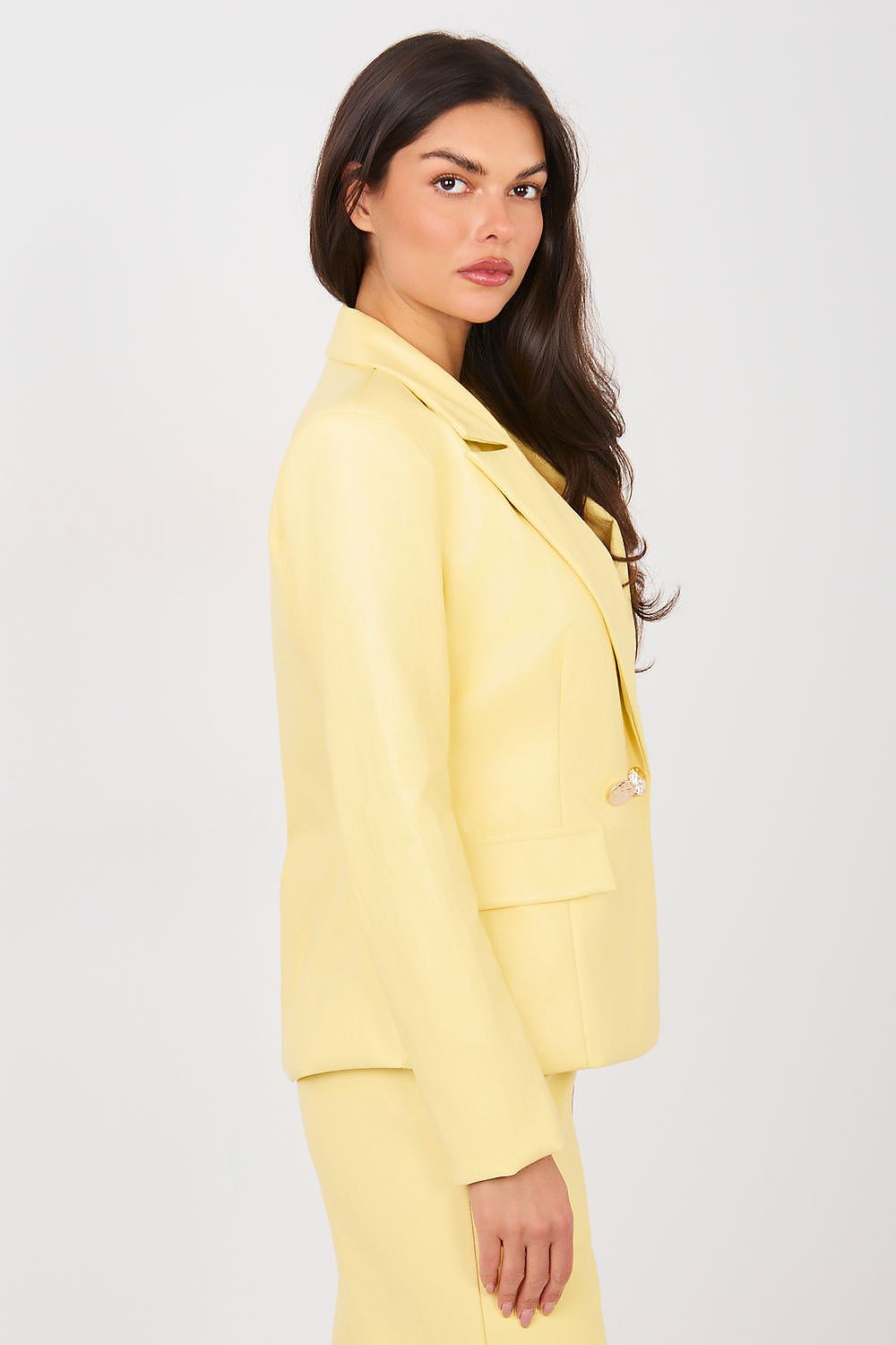 Woman wearing a yellow suit against a white background