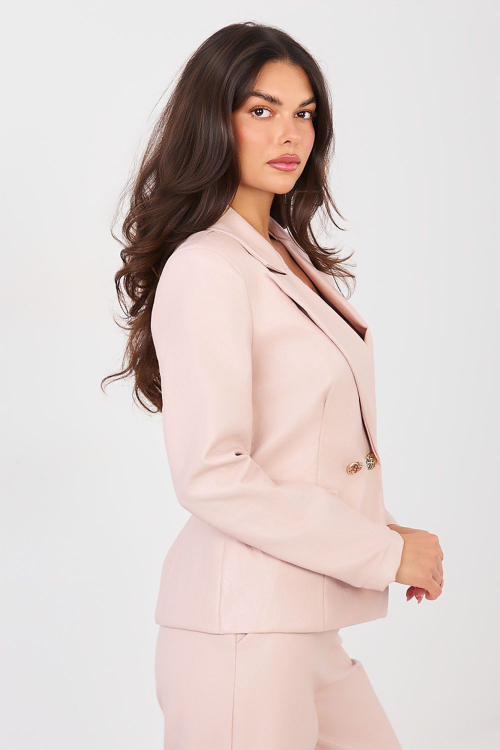 Woman wearing a light pink suit on a white background