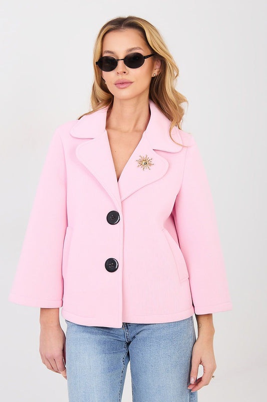 Woman wearing a pink coat with black buttons on a white background