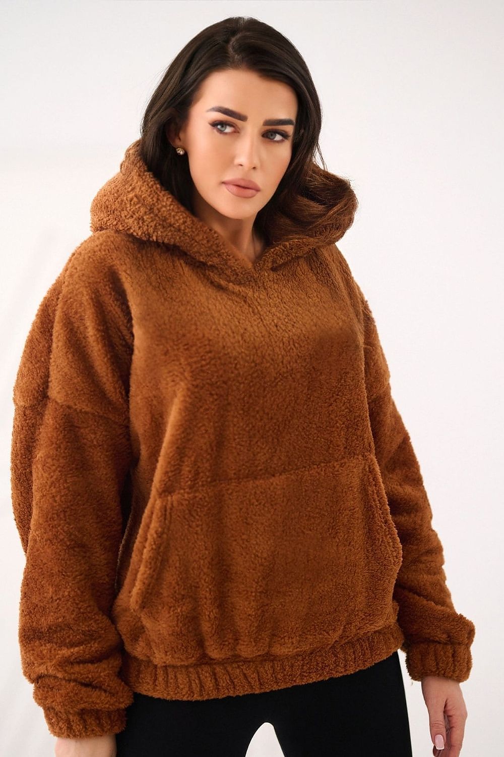 Woman wearing a brown fleece hoodie on a white background
