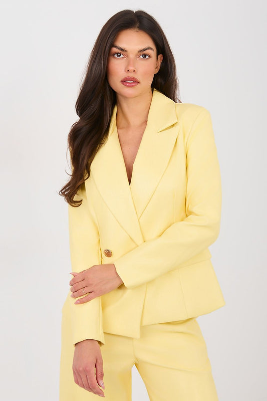 Woman wearing a yellow suit against a white background