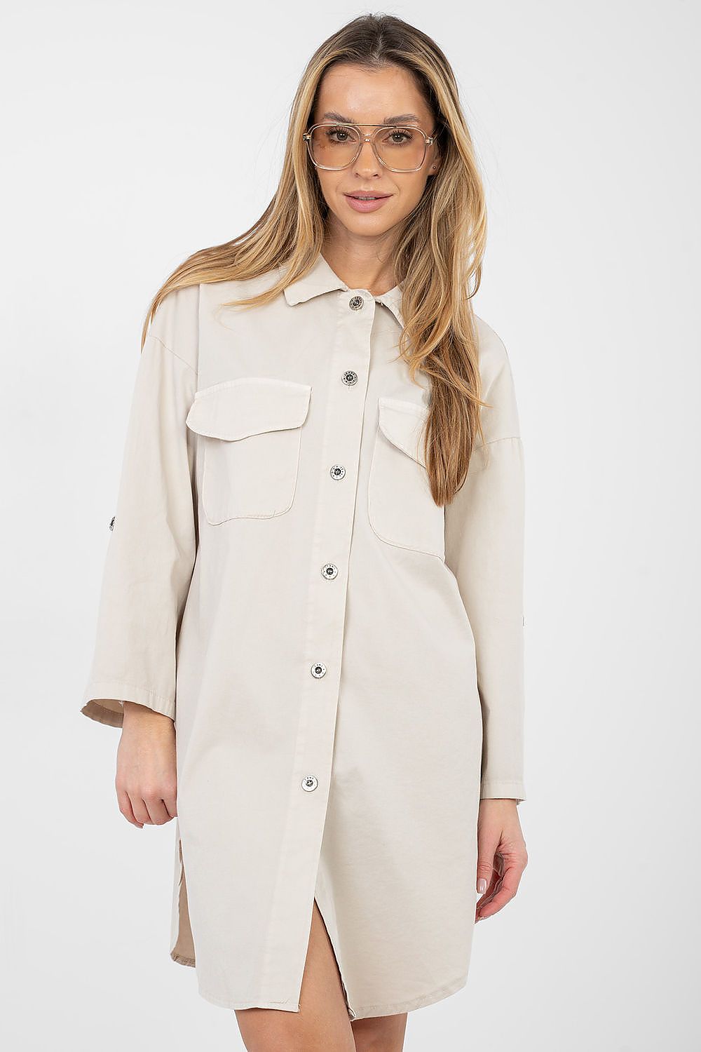 Woman wearing a beige button-up dress on a white background