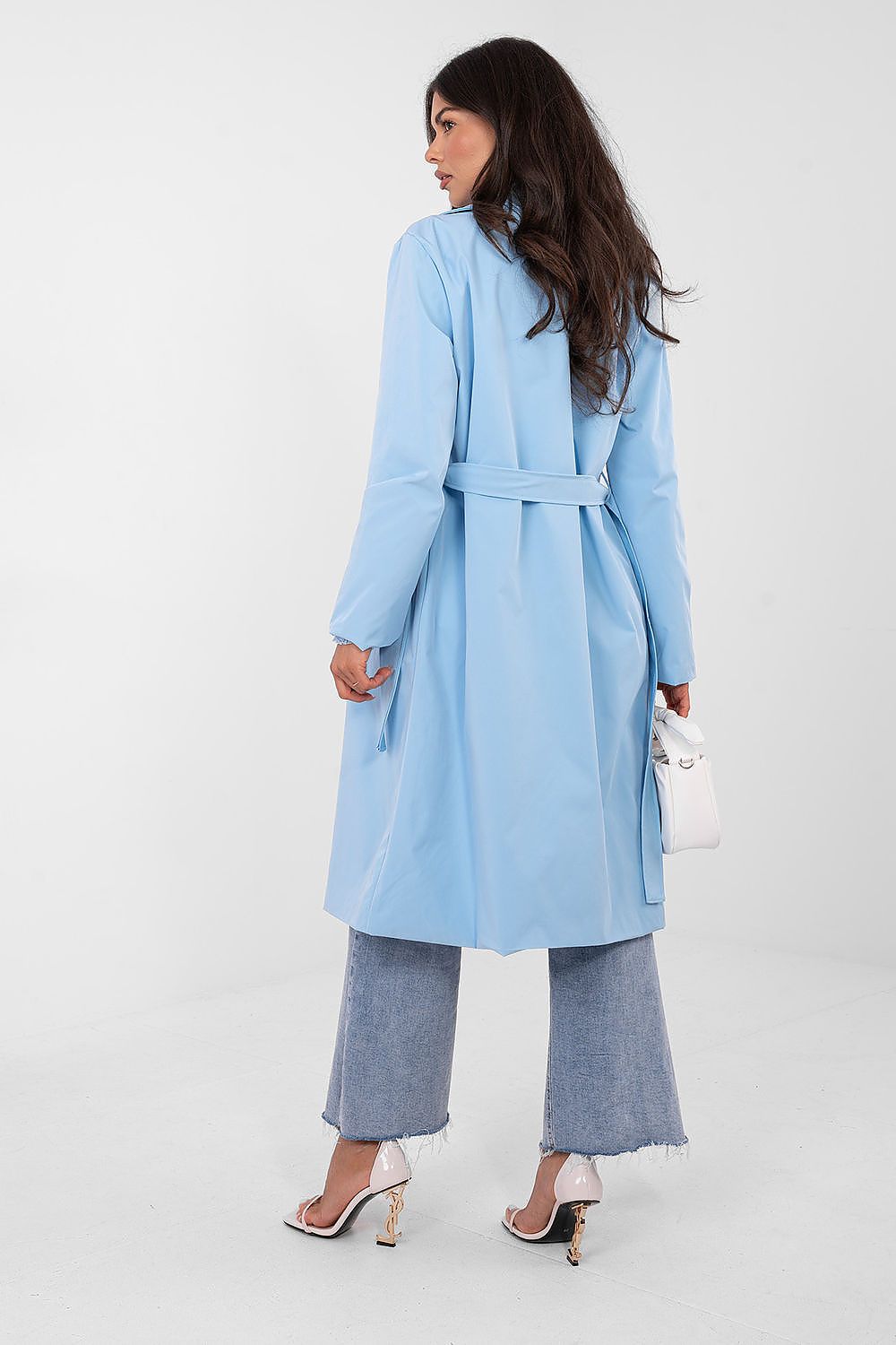 Woman wearing a light blue coat and pants on a white background