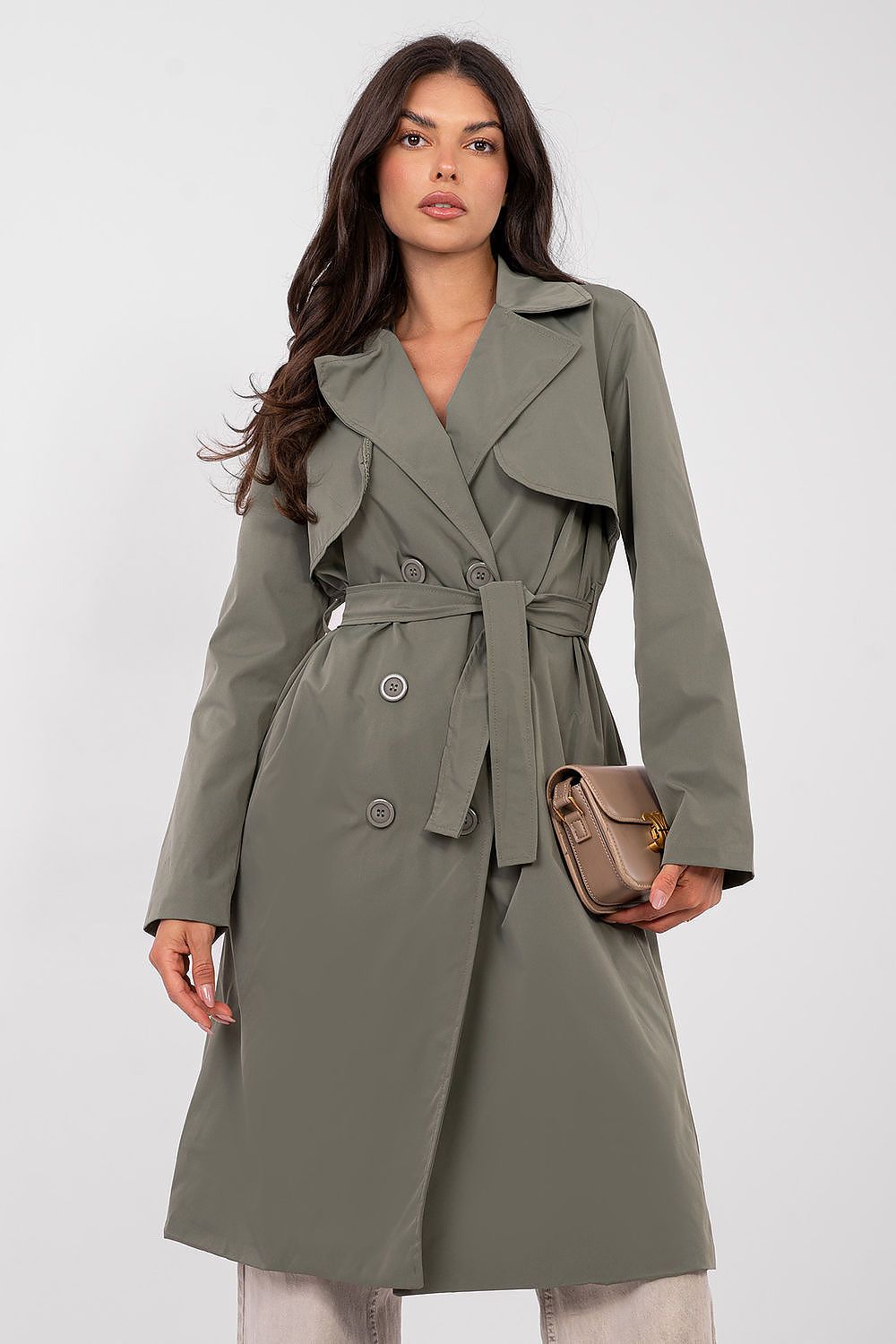 Woman wearing a green trench coat on a white background