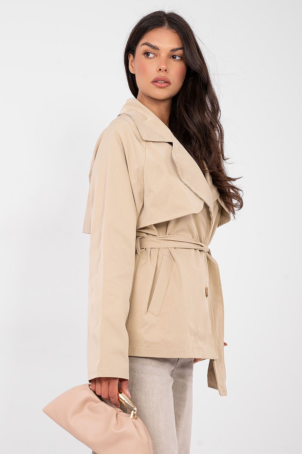Woman wearing a beige trench coat on a white background