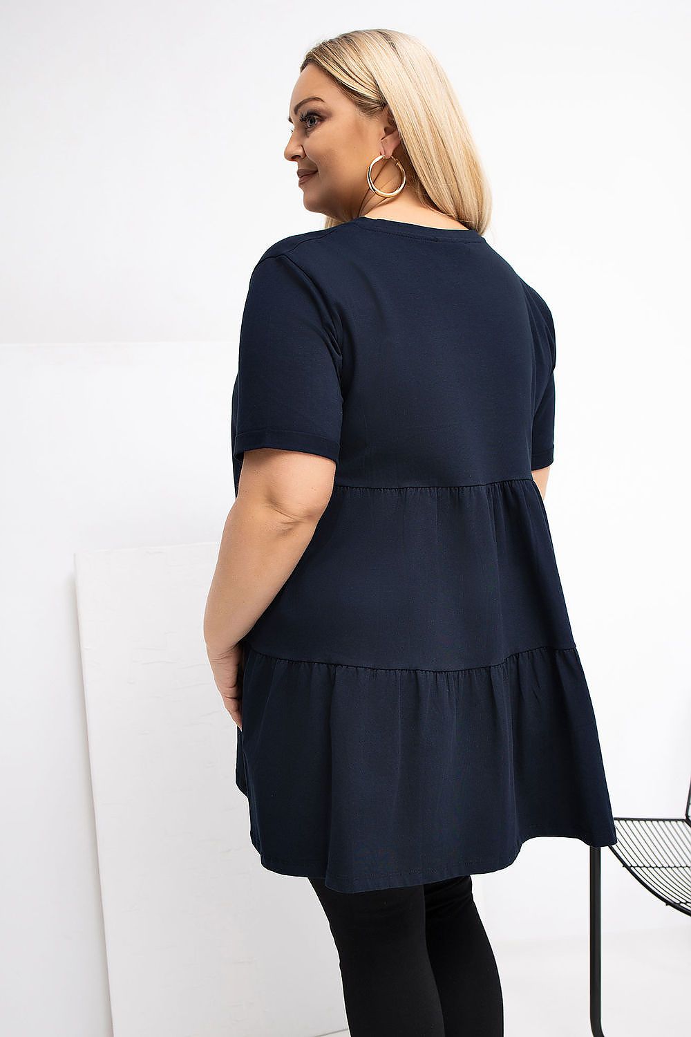 Woman wearing a navy blue dress with a white background
