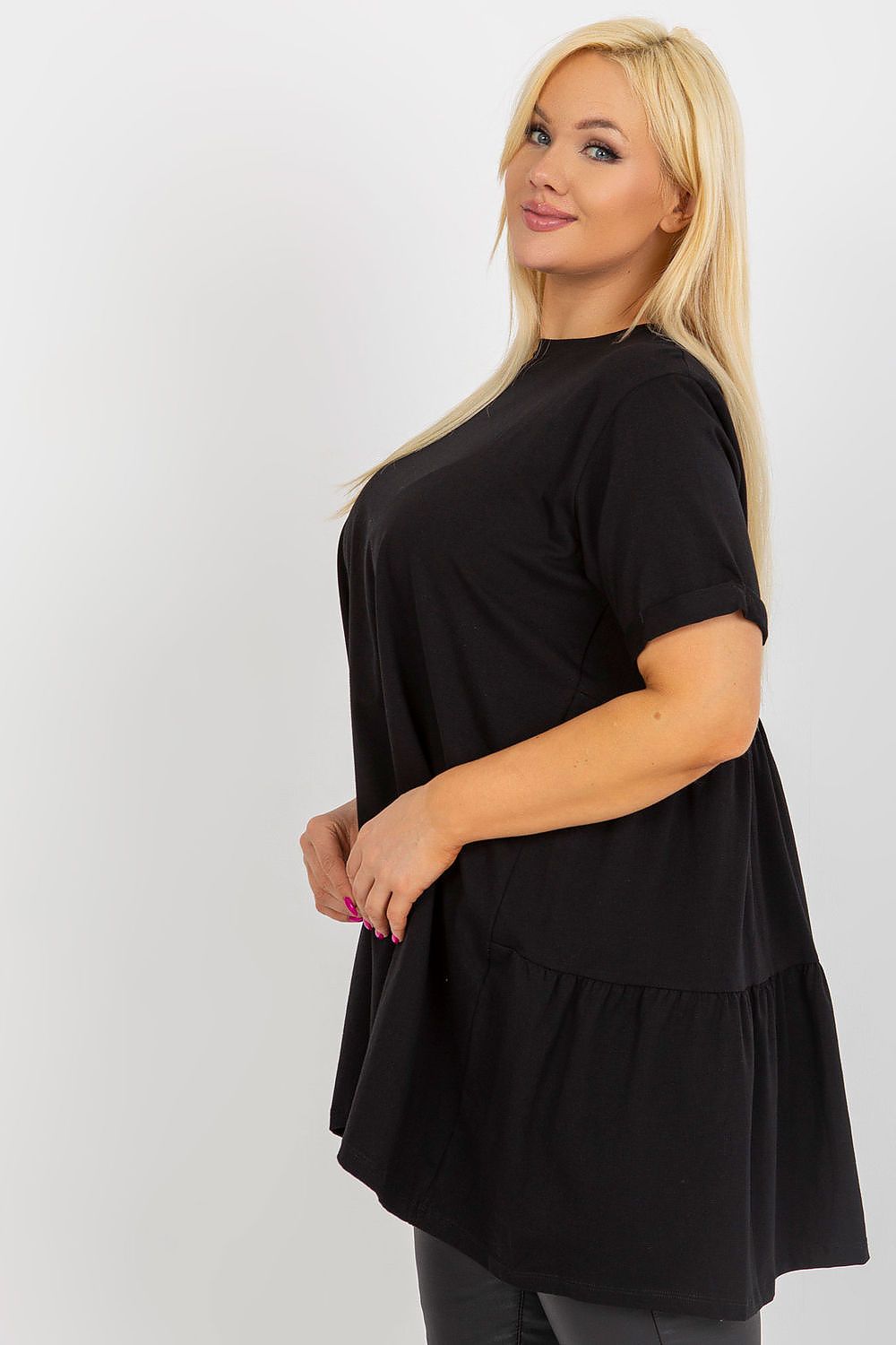 Woman wearing a black dress with a layered skirt on a white background