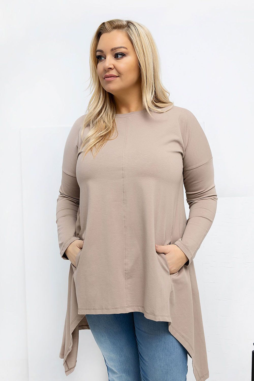 Woman wearing a beige long-sleeve top with a white background