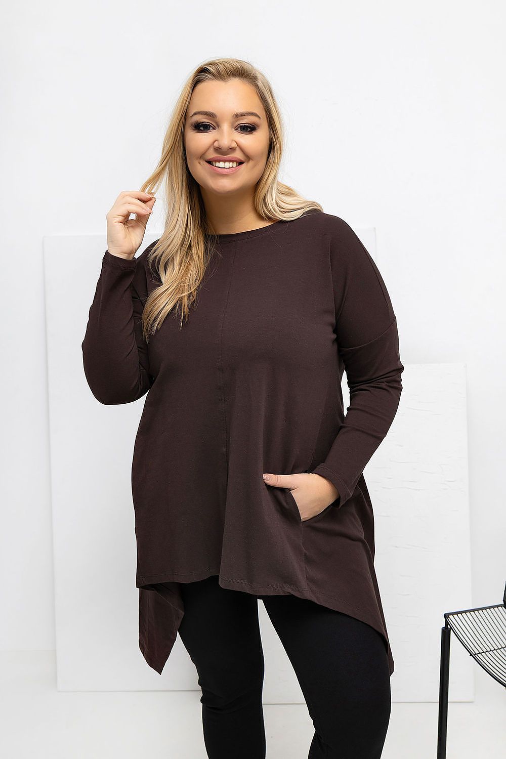 Woman wearing a brown long-sleeve top with a white background