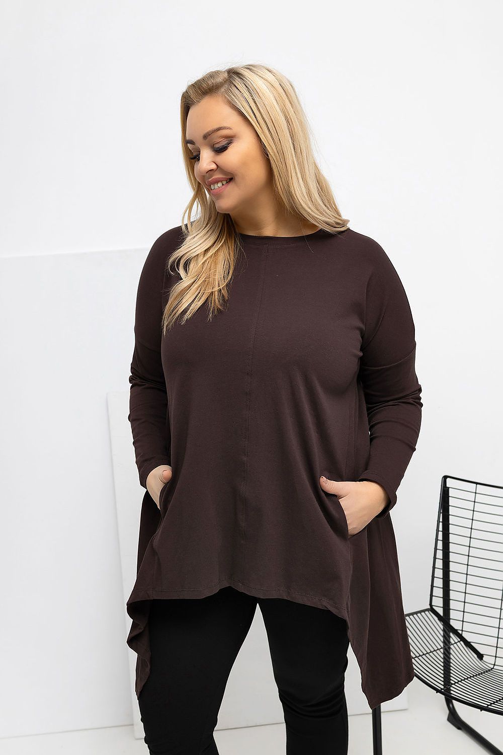  casual top featuring an asymmetrical hem, long sleeves and hidden side pockets.