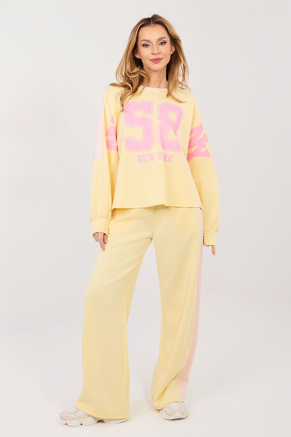 Woman wearing a yellow outfit with pink text on a white background