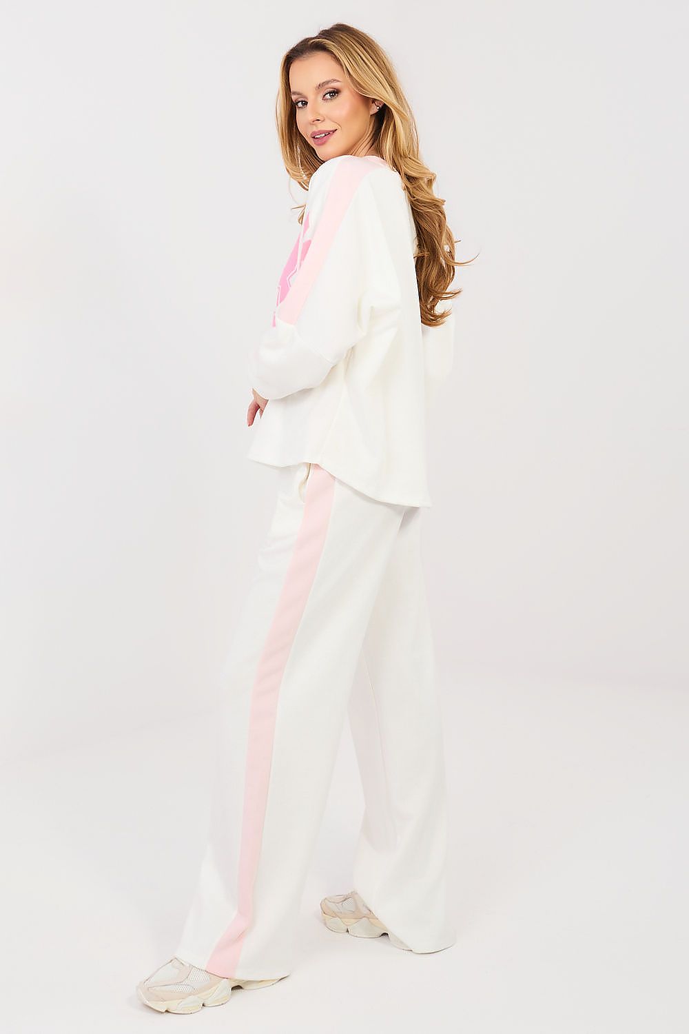 Woman wearing a white outfit with pink accents on a white background