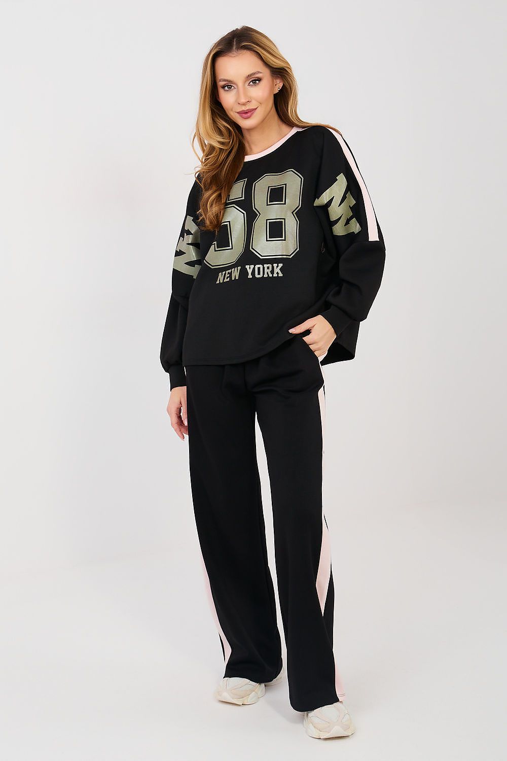 Woman wearing a black tracksuit with 'New York' text on a white background