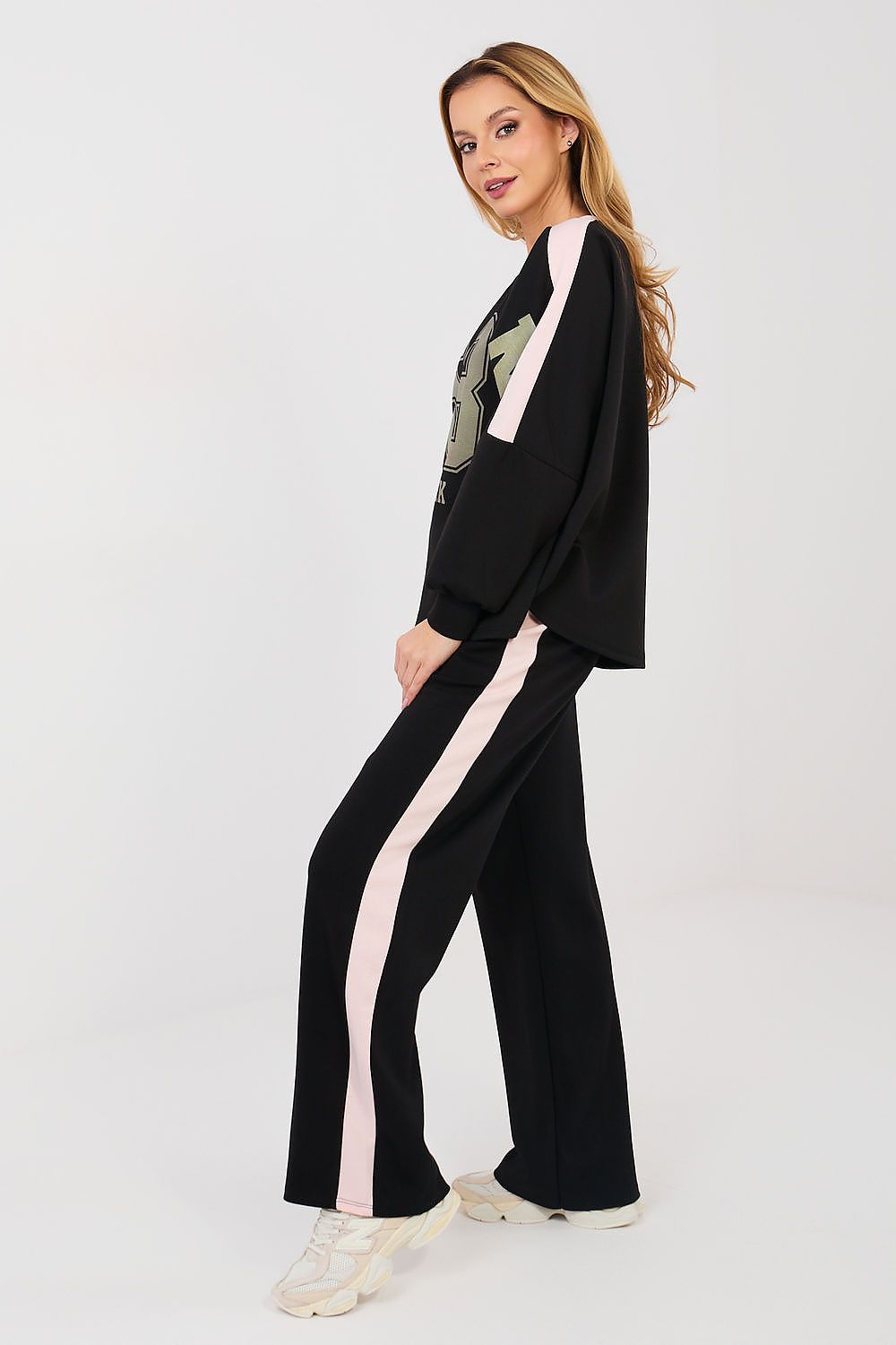 Woman wearing a black outfit with pink stripes on a white background