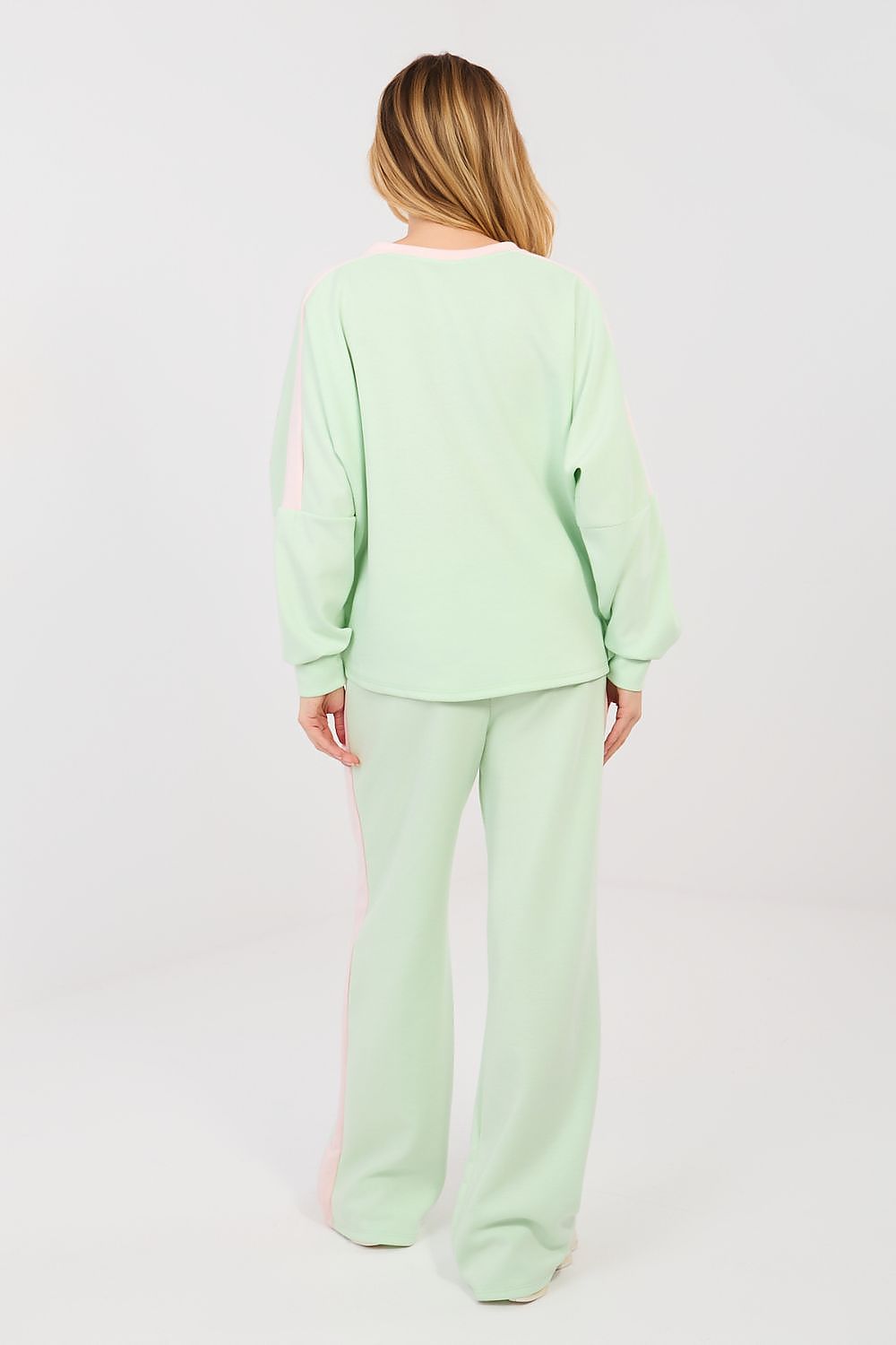 Person wearing a light green pajama set on a white background