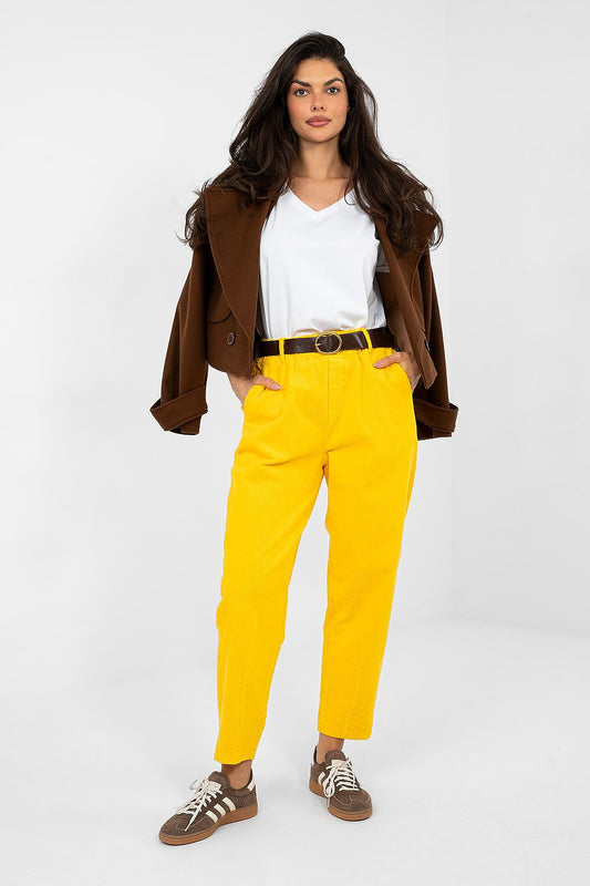 Woman wearing a brown jacket, white shirt, yellow pants, and brown shoes on a white background