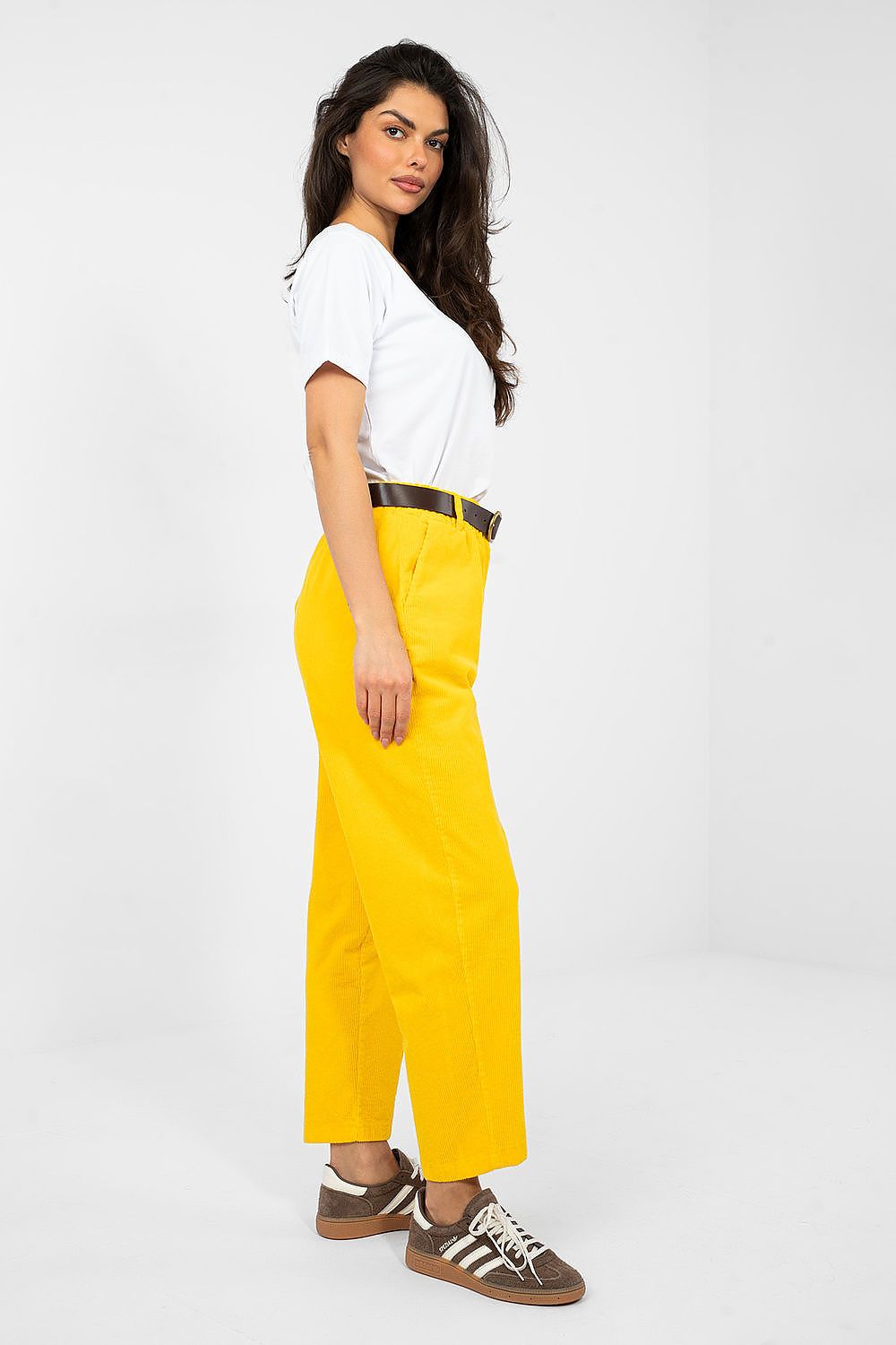 Woman wearing a white top and yellow pants on a white background