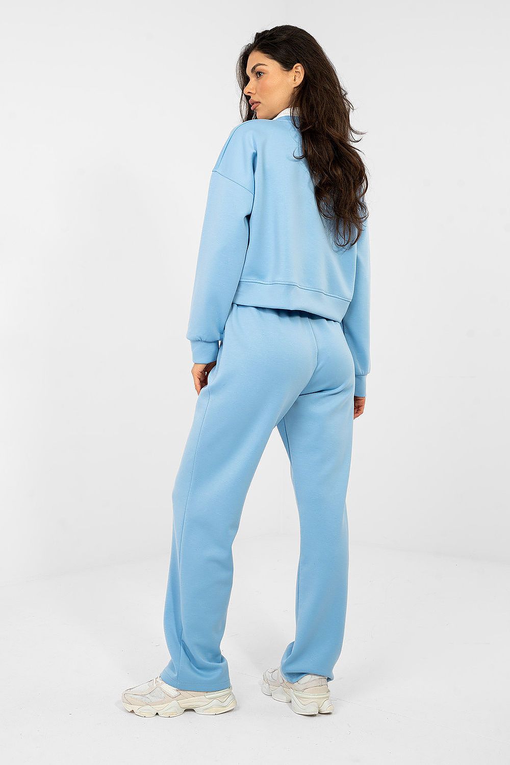 Woman wearing a light blue tracksuit on a white background
