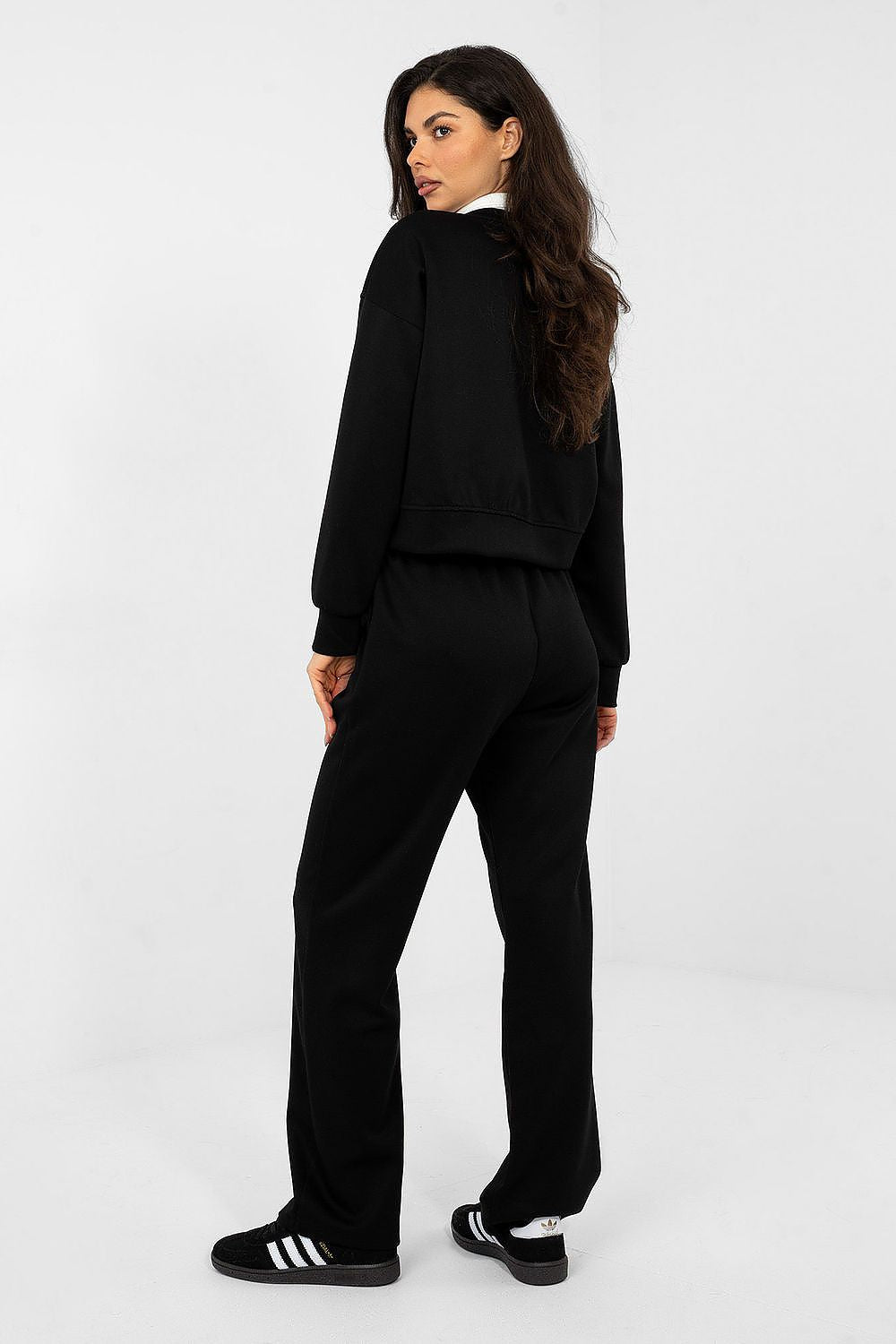 Woman wearing a black tracksuit on a white background