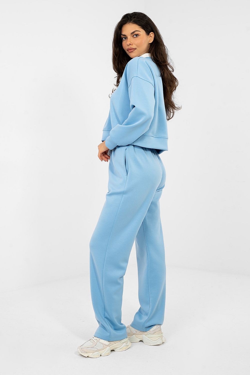 Woman wearing a light blue tracksuit on a white background