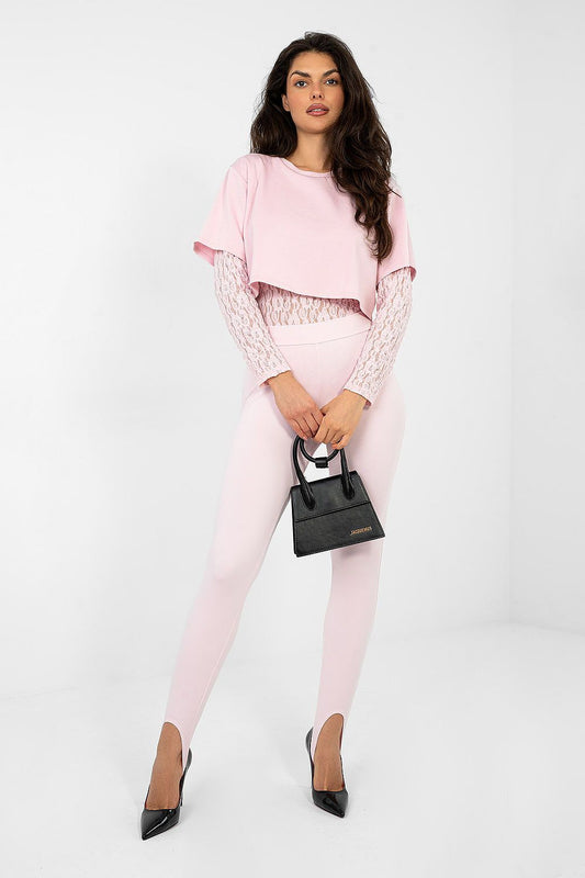 Woman wearing a pink outfit with a black handbag on a white background