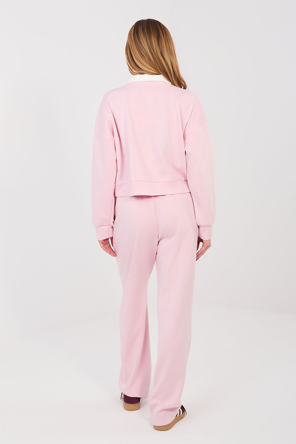 Person wearing a pink tracksuit on a white background