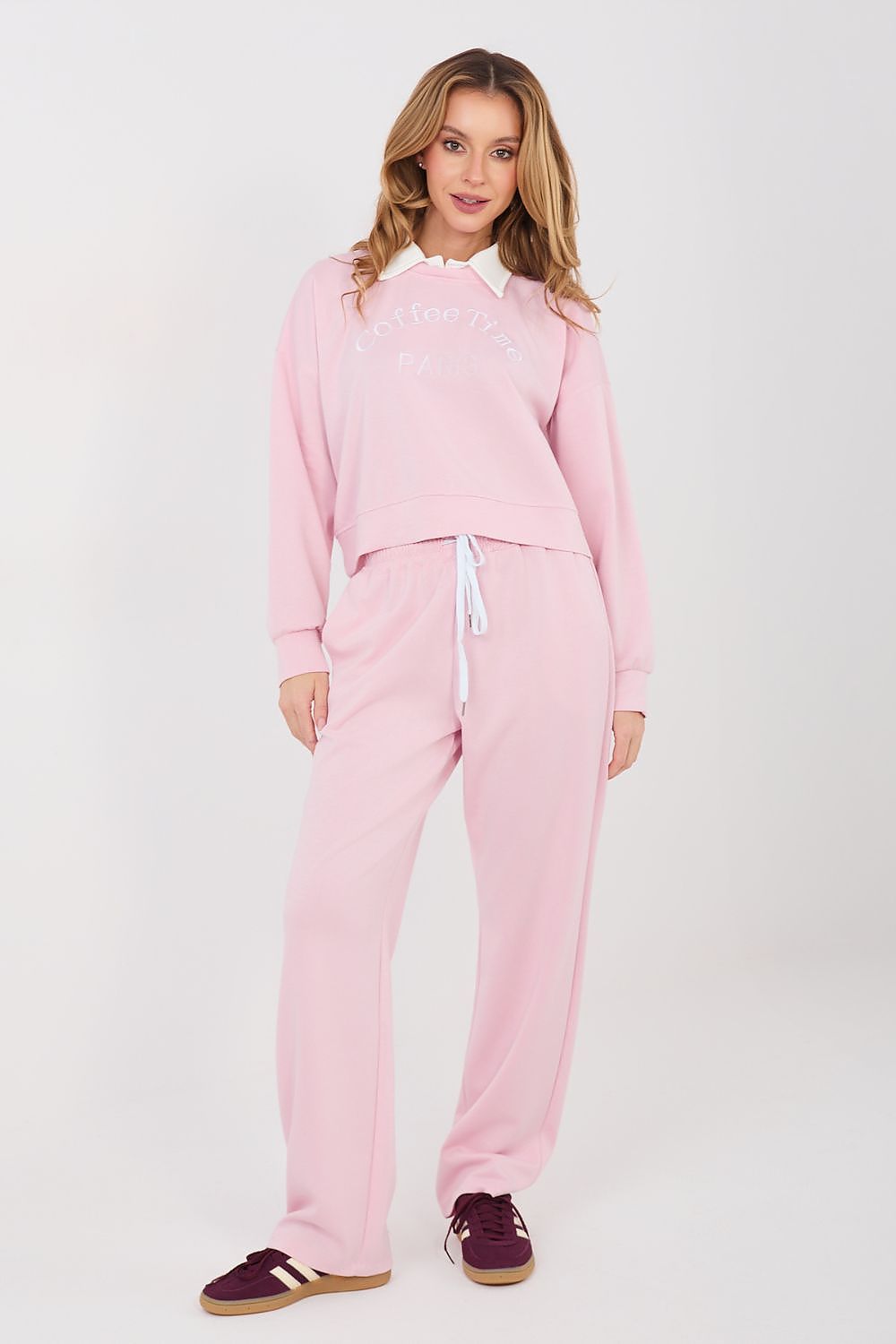 Woman wearing a pink tracksuit on a white background
