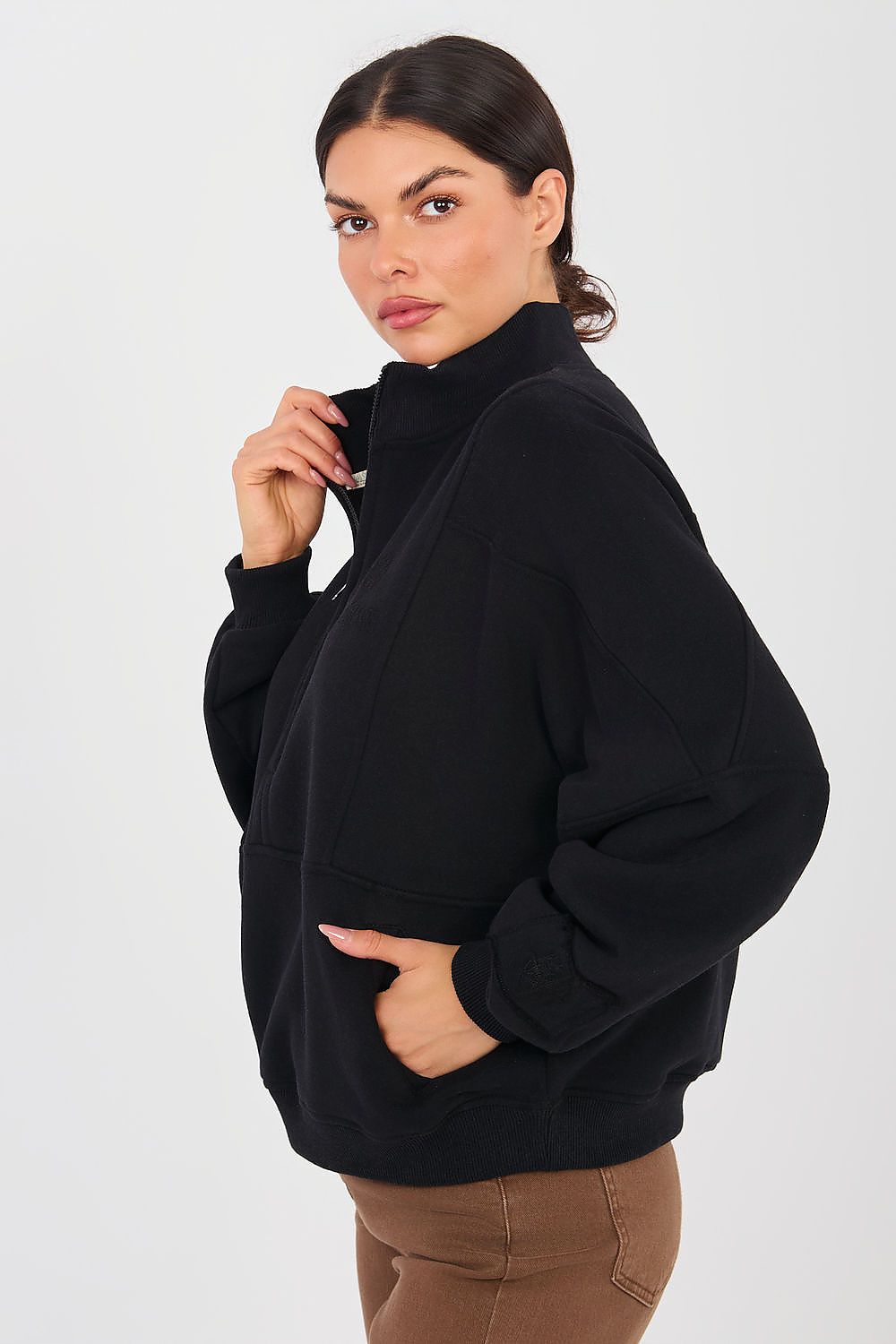 Woman wearing a black oversized sweater against a white background