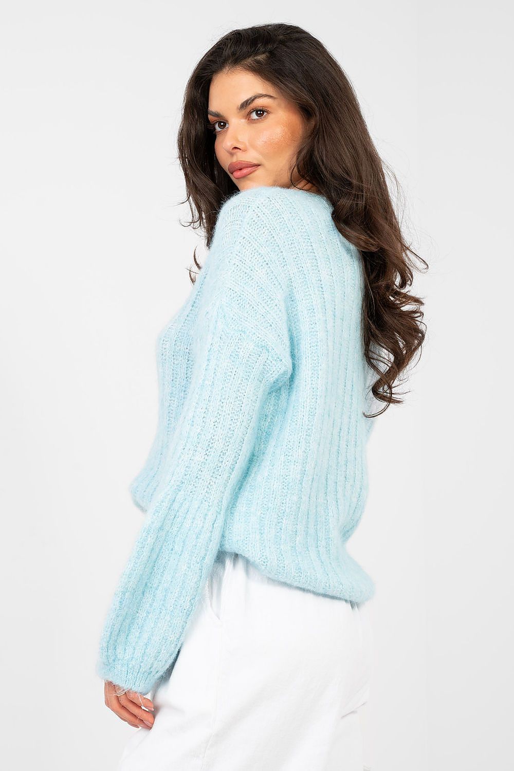 Woman wearing a light blue sweater against a white background