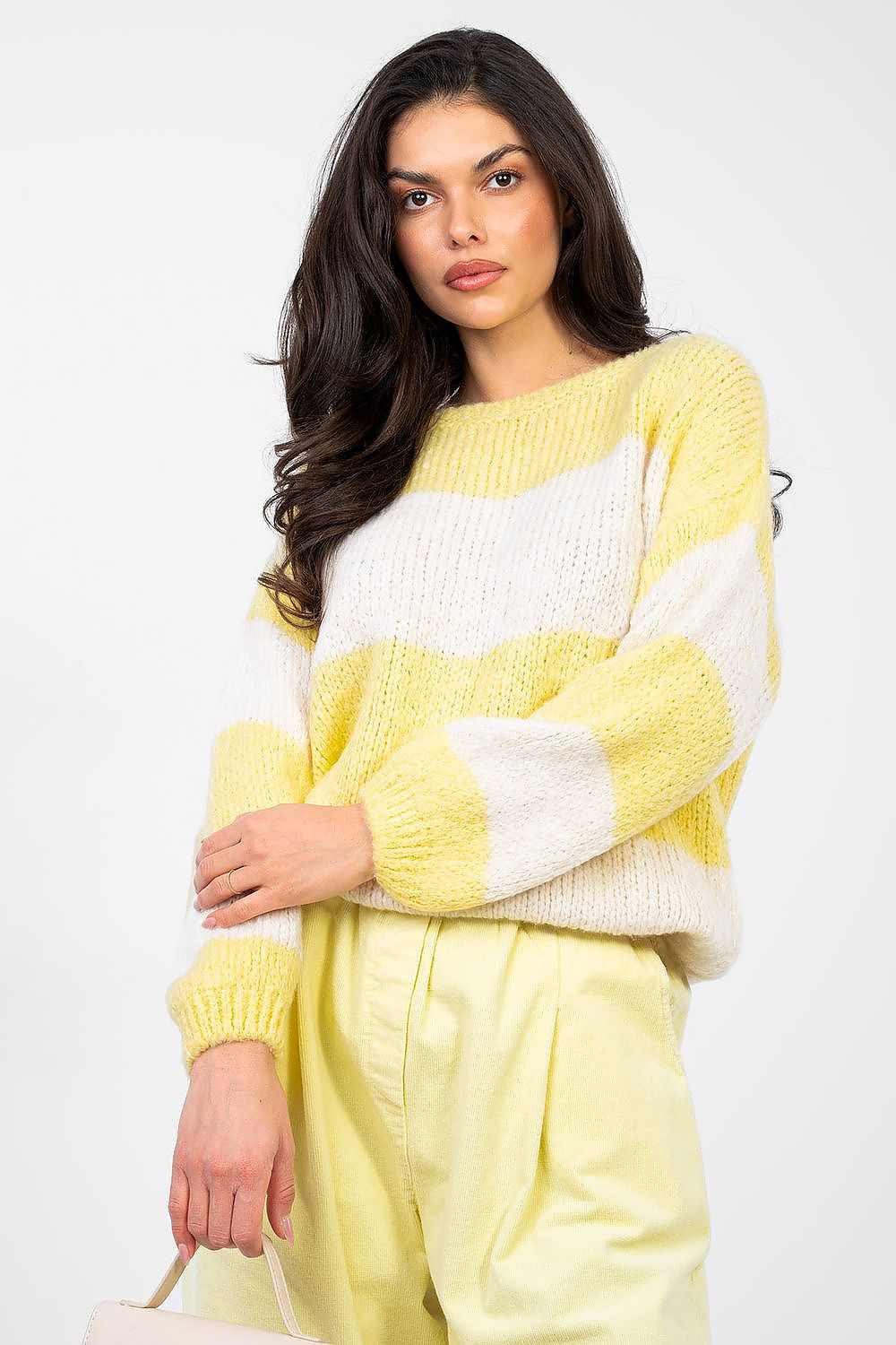 Woman wearing a yellow and white striped sweater with matching pants on a white background