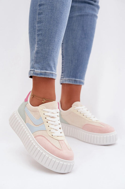 Pastel-colored sneakers with a white sole worn with blue jeans on a light gray background
