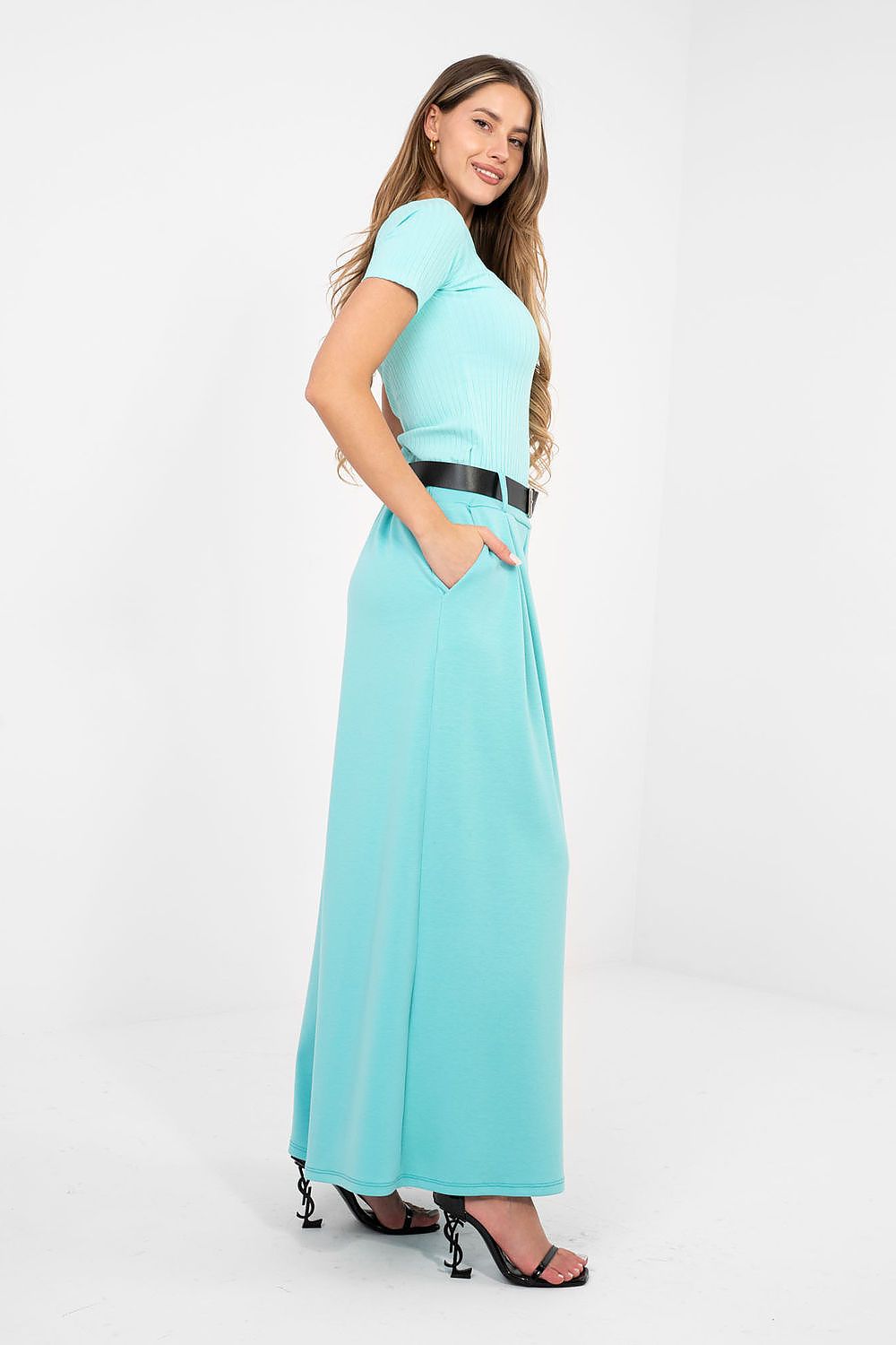 Woman wearing a light blue dress with a belt on a white background